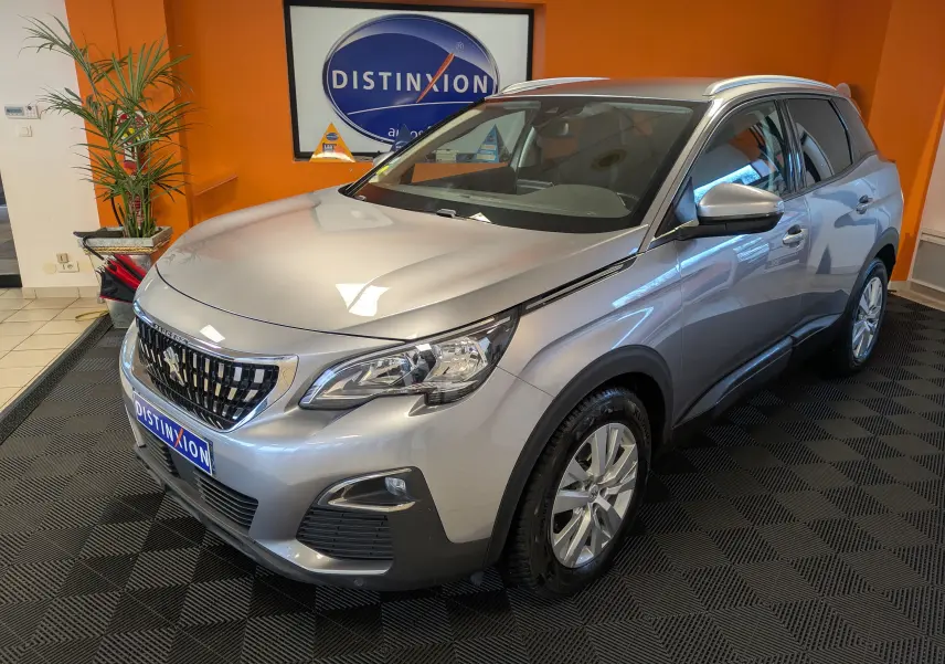 Peugeot 3008 gris Arthense vue 3/4 avant droit en intérieur avec calandre distinctive et jantes alliage.