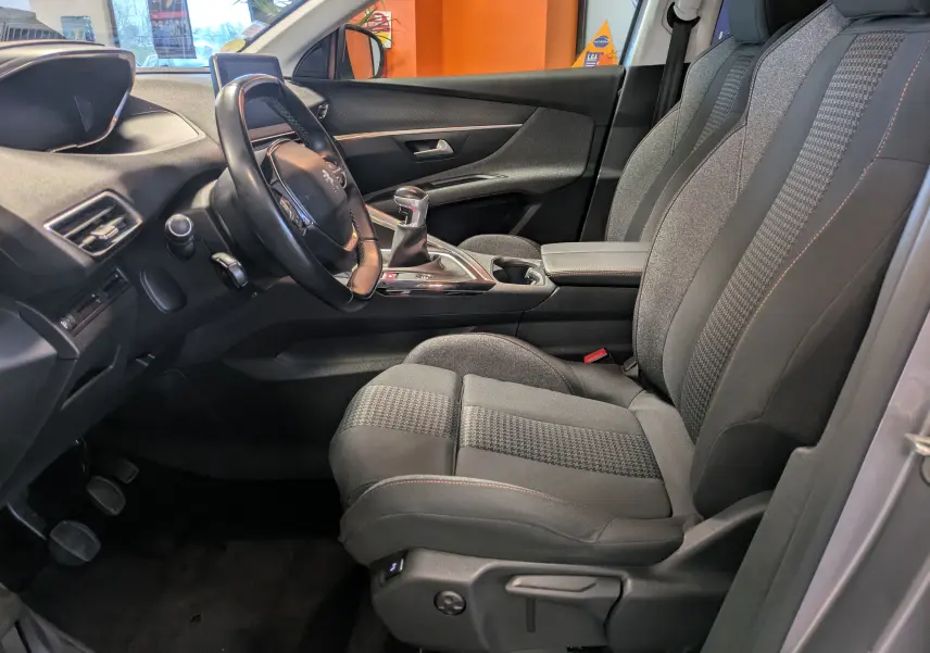 Intérieur côté conducteur du Peugeot 3008 gris Arthense, montrant les sièges tissu et la boîte manuelle au premier plan.