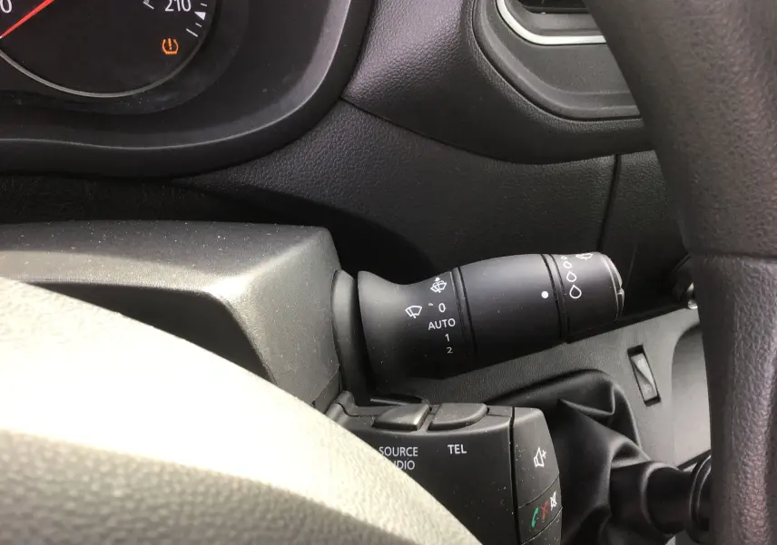 Gros plan sur la commande d’essuie-glace à droite du volant dans l’habitacle noir du Renault Master blanc 2020.