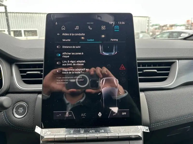 Écran tactile central du tableau de bord du Renault Captur 2026, affichant les aides à la conduite, intérieur noir.