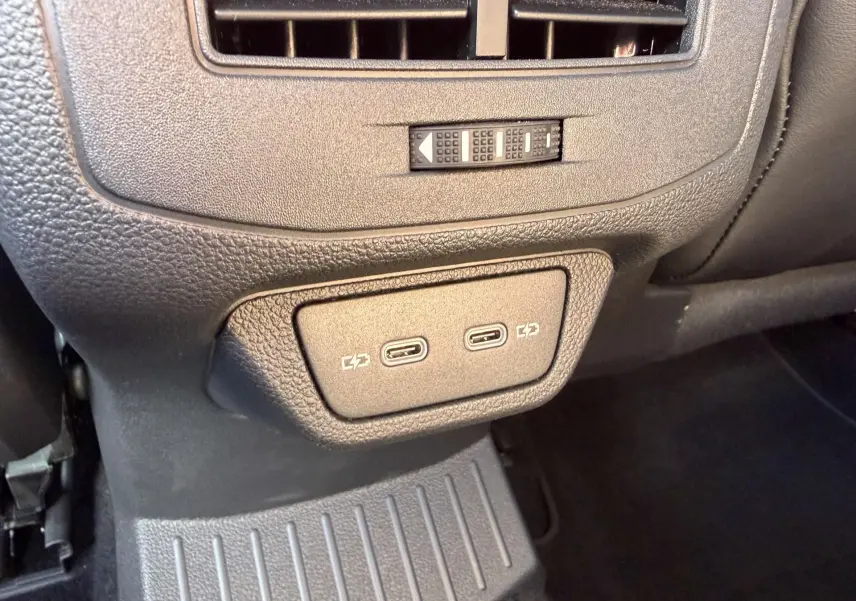 Vue rapprochée des ports USB-C doubles pour recharge situés à l'arrière de la console centrale du Volkswagen T-Roc noir.