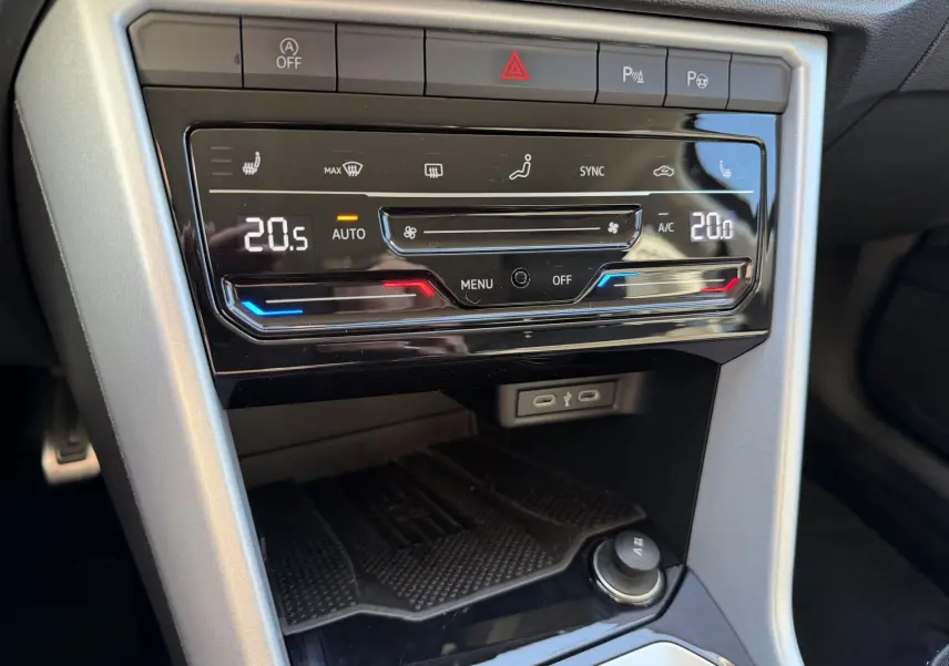 Vue rapprochée de la console centrale du Volkswagen T-Roc 2025, affichant la climatisation automatique tactile bi-zone.
