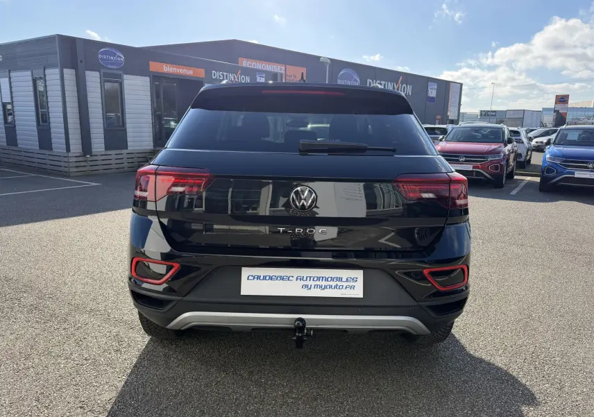Vue arrière d'un Volkswagen T-Roc noir 2025 avec attelage amovible et feux arrière LED distinctifs.