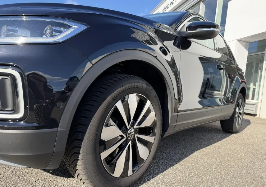 Vue 3/4 avant droit du Volkswagen T-Roc noir, mettant en valeur la jante alliage 17 pouces et les détails du phare LED.