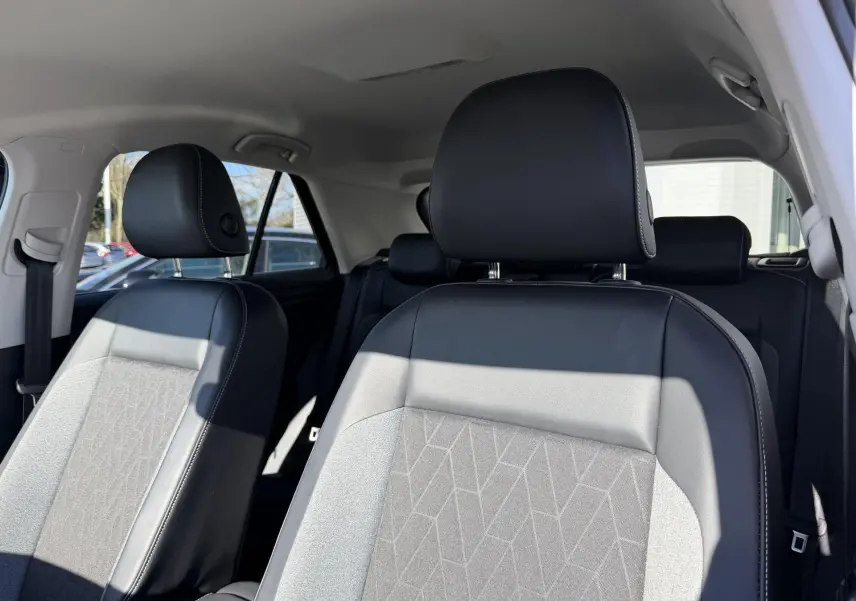 Vue intérieure des sièges avant en cuir noir et tissu gris avec motifs géométriques du Volkswagen T-Roc 2025.