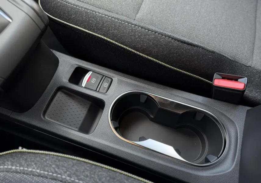 Gros plan sur la console centrale noire du Renault Captur 2026 avec porte-gobelets et frein à main électrique.