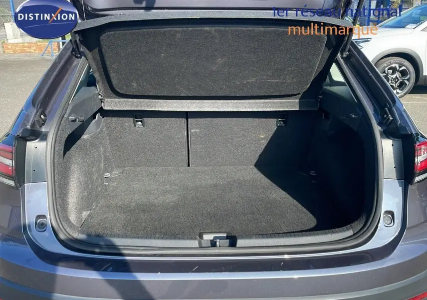 Coffre ouvert en vue arrière d'un Volkswagen Taigo gris cendre 2022, montrant un espace de chargement vide et propre.