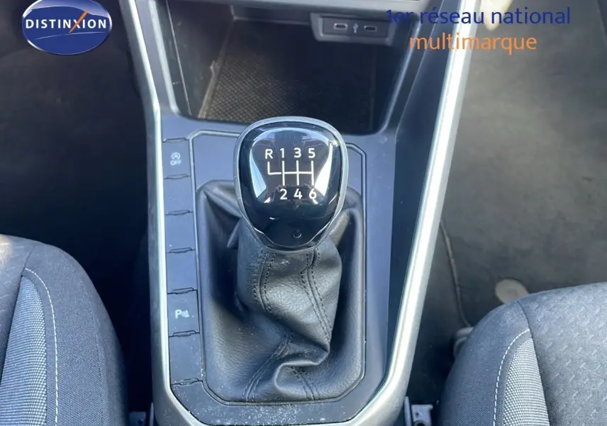 Le levier de vitesse manuel noir de la Volkswagen Taigo 1.0 TSI 110CH LIFE 2022, entouré de sièges tissu gris.