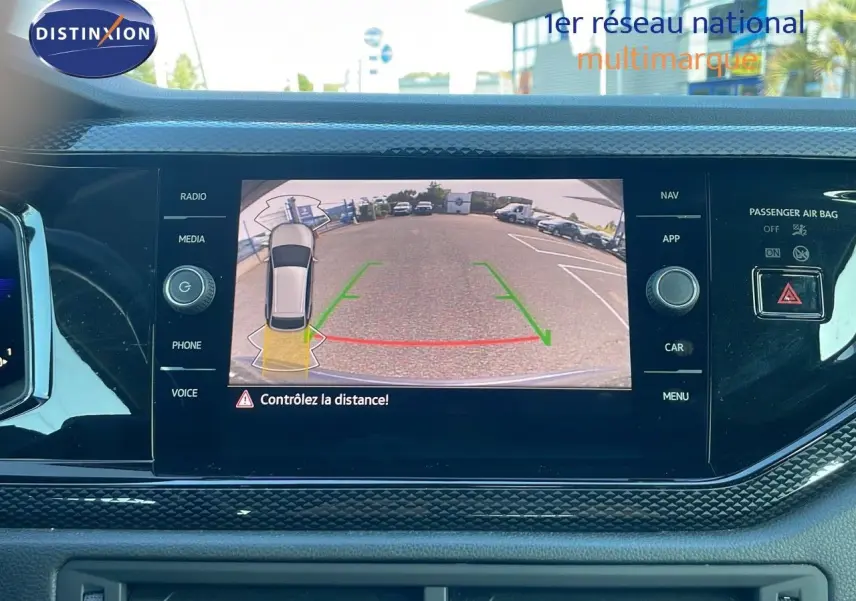 Vue intérieure du tableau de bord du Volkswagen Taigo gris cendre 2022 avec écran de caméra de recul affichant l'arrière du véhicule.