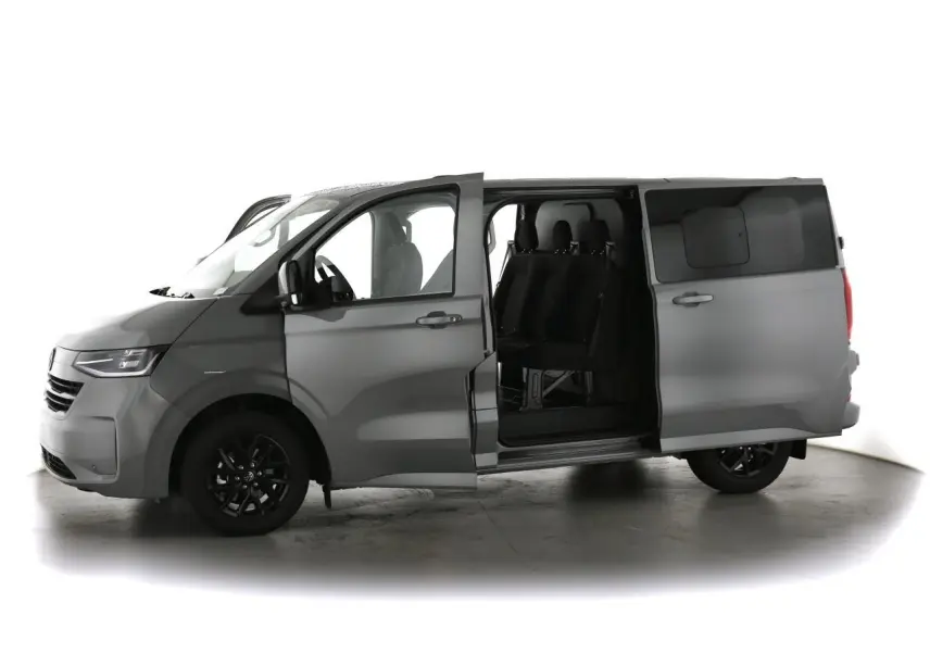 Vue de profil gauche d'un Volkswagen Transporter T7 gris Stone avec porte coulissante ouverte révélant les sièges arrière noirs.