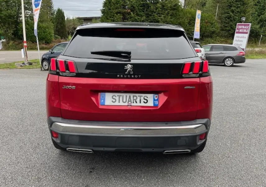 Vue arrière d'un Peugeot 3008 GT Line rouge Ultimate avec hayon noir et feux arrière à griffes LED distinctifs.