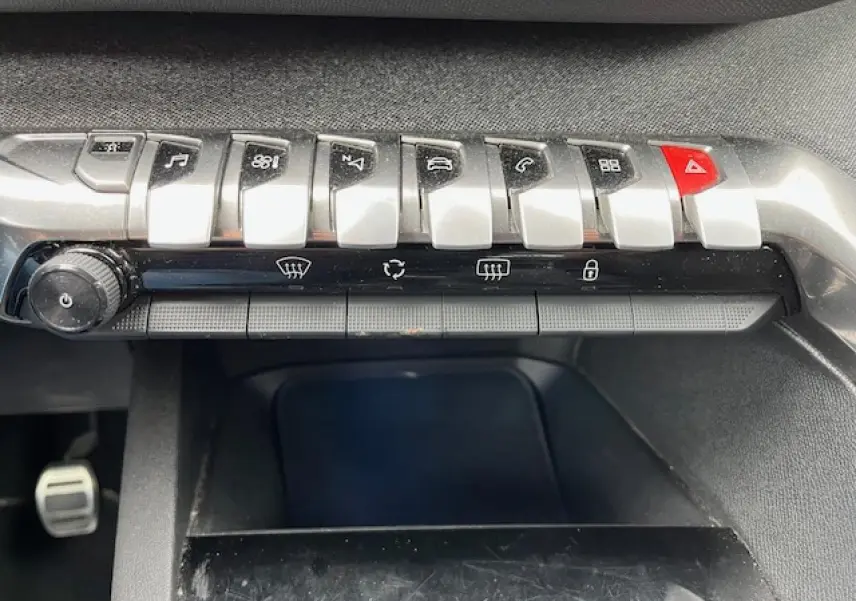 Panneau de commandes central du Peugeot 3008 GT Line 2019 avec boutons argentés et alerte rouge, intérieur noir.