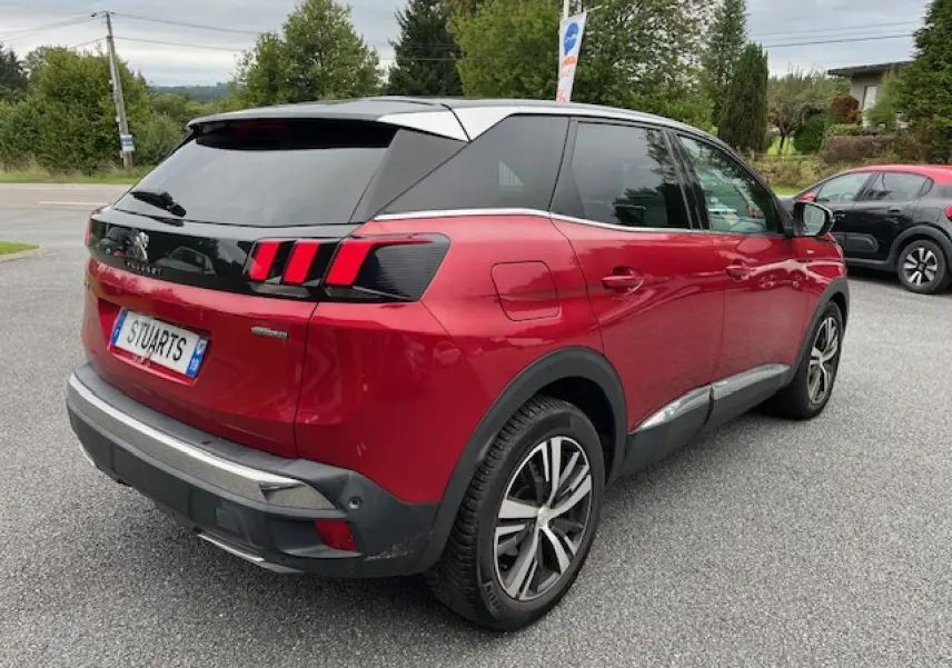 Vue 3/4 arrière droite d'un Peugeot 3008 rouge Ultimate avec toit noir et jantes alliage bi-ton diamantées.