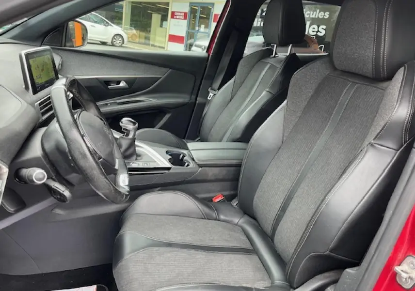Intérieur avant du Peugeot 3008 GT Line 2019 rouge, sièges TEP et tissu noirs avec volant cuir perforé.