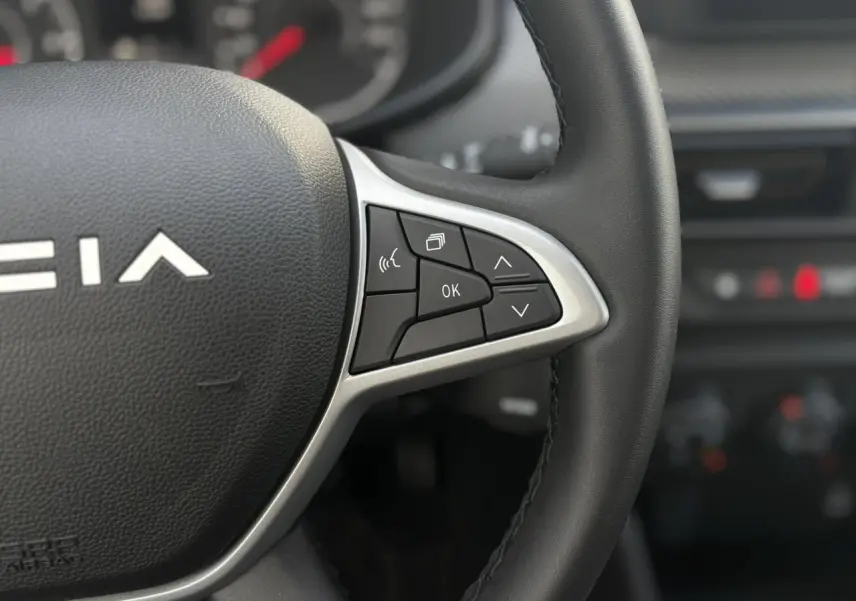 Gros plan sur le volant noir Soft Feel de la Dacia Sandero Stepway 2025 avec commandes multifonctions sur le côté droit.