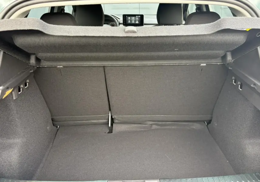 Vue intérieure du coffre spacieux de la Dacia Sandero Stepway 2025, avec banquette arrière rabattable et habillage gris foncé.