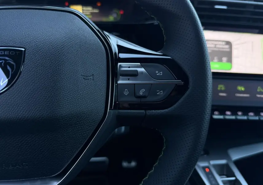 Gros plan sur le volant cuir perforé noir avec commandes intégrées du Peugeot 408 Hybrid 145 e-DSC6 GT.