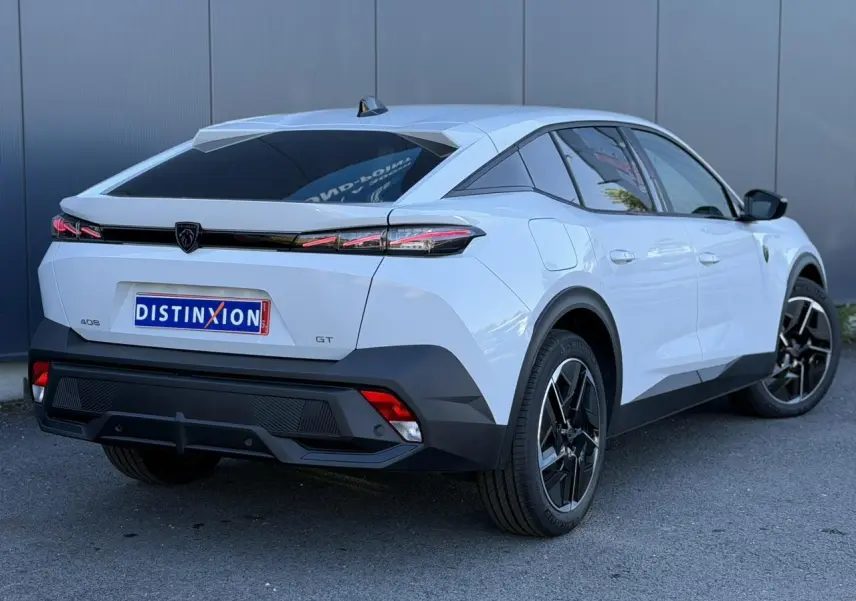 Vue 3/4 arrière droite du Peugeot 408 Hybrid GT blanc Okenite avec jantes alliage 19 pouces et feux LED distinctifs.