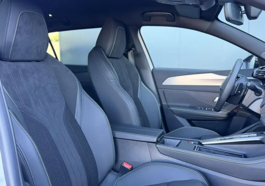 Intérieur avant droit du Peugeot 408 Hybrid blanc Okenite avec sièges alcantara exécutive et volant cuir perforé.