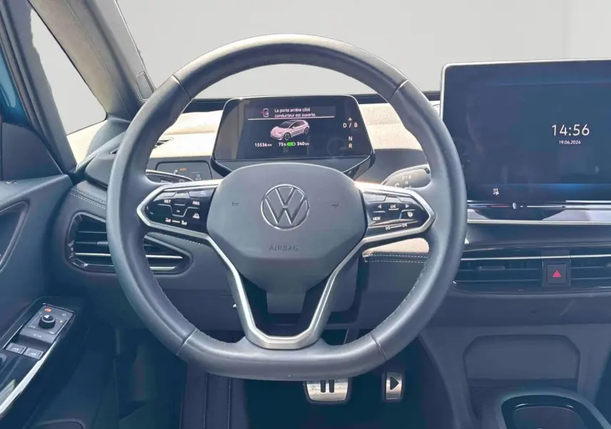 Vue intérieure centrée sur le volant multifonction et l'écran digital du tableau de bord d'une Volkswagen ID.3 bleue.