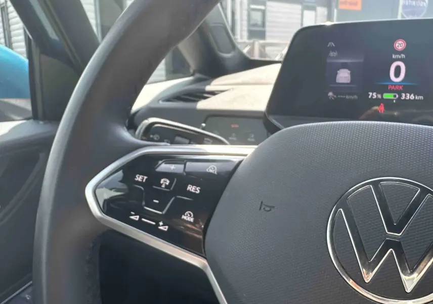 Gros plan sur le volant multifonction noir et l'écran digital du tableau de bord d'une Volkswagen ID.3 électrique.