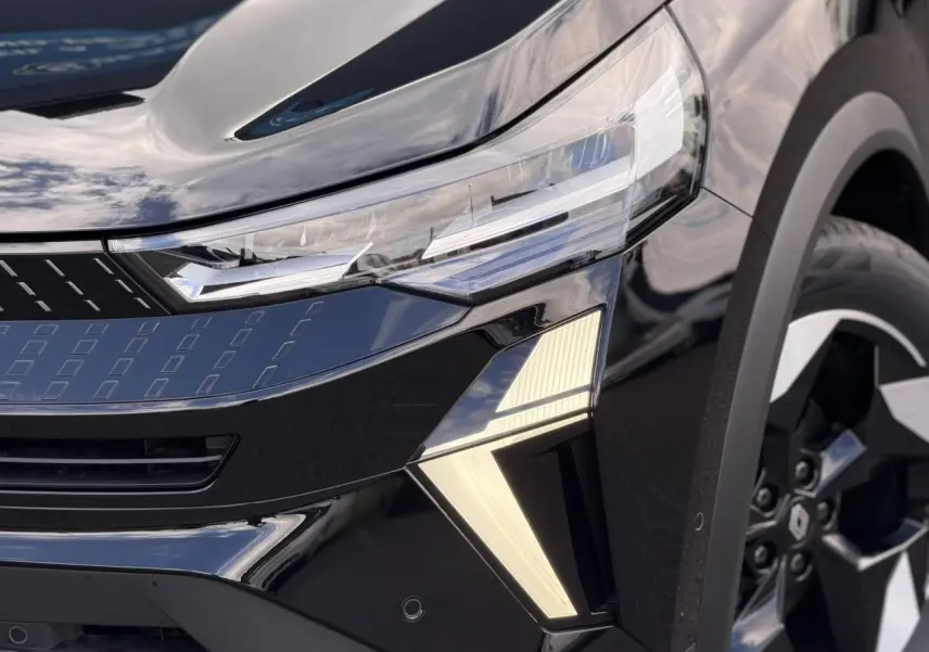 Gros plan sur l’avant droit noir étoilé du Renault Captur 2026, mettant en valeur les phares LED et la jante aluminium 18 pouces.