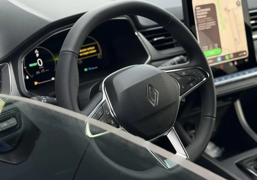 Vue rapprochée du volant noir en textile refined du Renault Captur 2026 avec tableau de bord numérique et écran tactile.