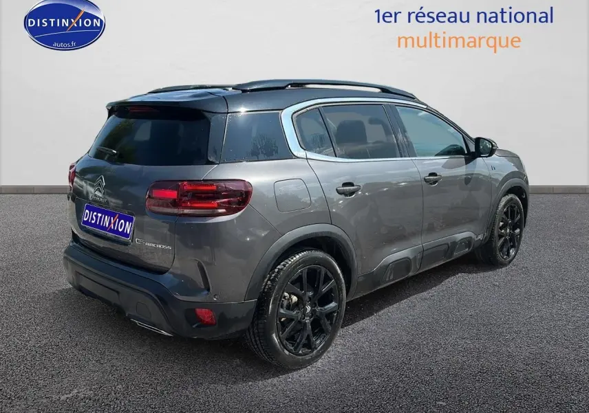 Vue 3/4 arrière droite d'un Citroën C5 Aircross gris platinium avec jantes noires et vitres teintées.