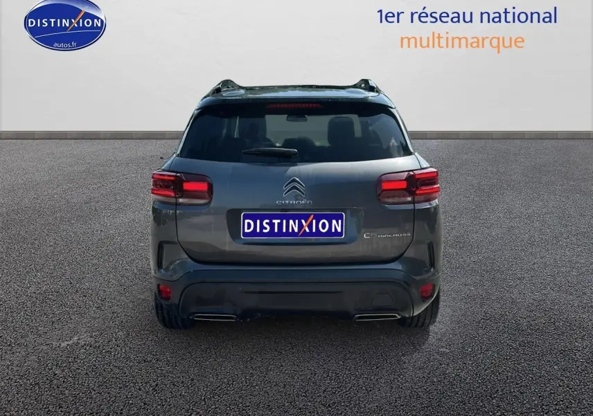Vue arrière d'un Citroën C5 Aircross gris platinium avec feux LED et barres de toit visibles.