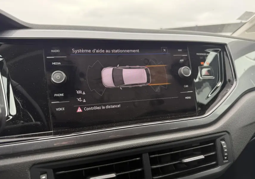 Écran tactile du système d'aide au stationnement dans le tableau de bord d'une Volkswagen Polo bleue 2021.