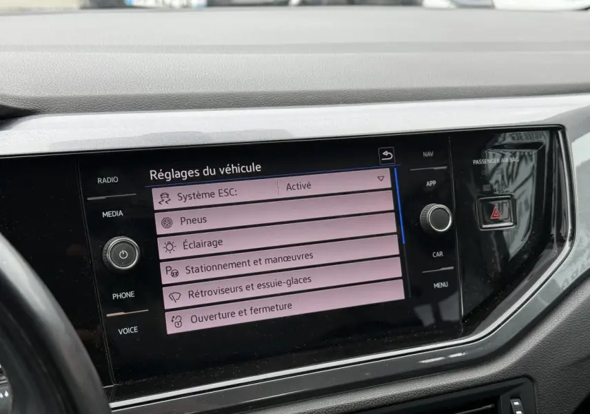 Écran tactile central affichant les réglages du véhicule dans l'habitacle d'une Volkswagen Polo bleue 2021.
