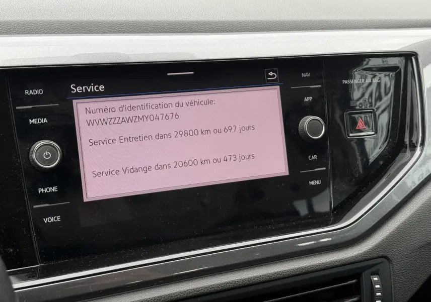 Écran tactile central affichant les informations de service dans l'habitacle d'une Volkswagen Polo 1.0 TSI bleu.