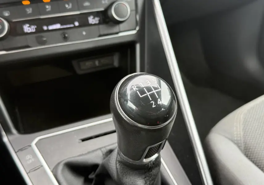 Le levier de vitesses manuel noir de la Volkswagen Polo 1.0 TSI R-Line 2021, avec console grise et siège tissu visible.