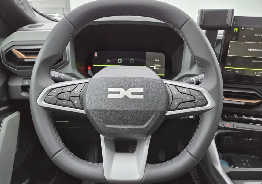Vue frontale du volant noir et gris du Dacia Bigster 2025 avec commandes intégrées et tableau de bord numérique.