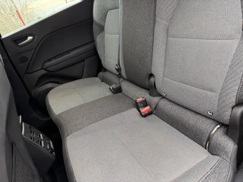Vue intérieure sur les sièges arrière gris du Renault Captur 2025, avec ceinture de sécurité et porte côté gauche visible.