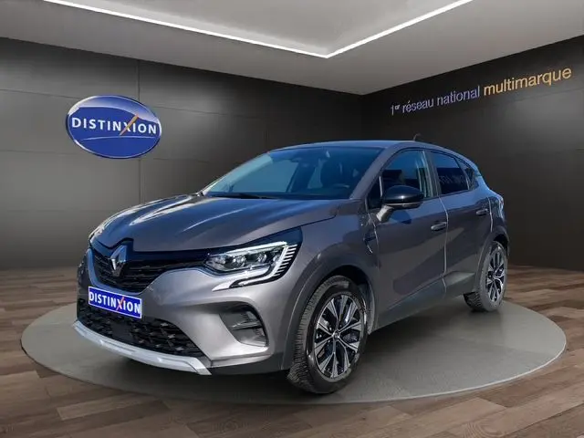 Vue 3/4 avant droite du Renault Captur E-Tech Full Hybrid 145 gris Cassiopée, avec jantes alliage et phares LED allumés.