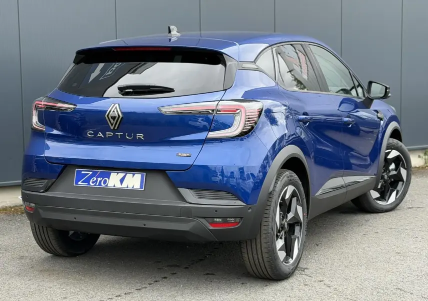 Vue 3/4 arrière droite du Renault Captur 2026 bleu Iron avec jantes aluminium noires et feux LED distinctifs.