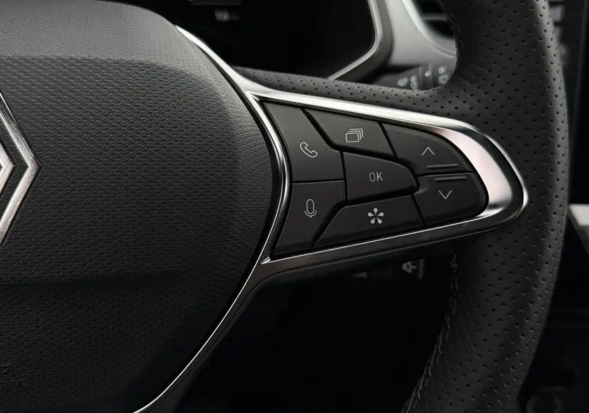Gros plan sur les commandes à droite du volant perforé noir du Renault Captur hybride 2026.