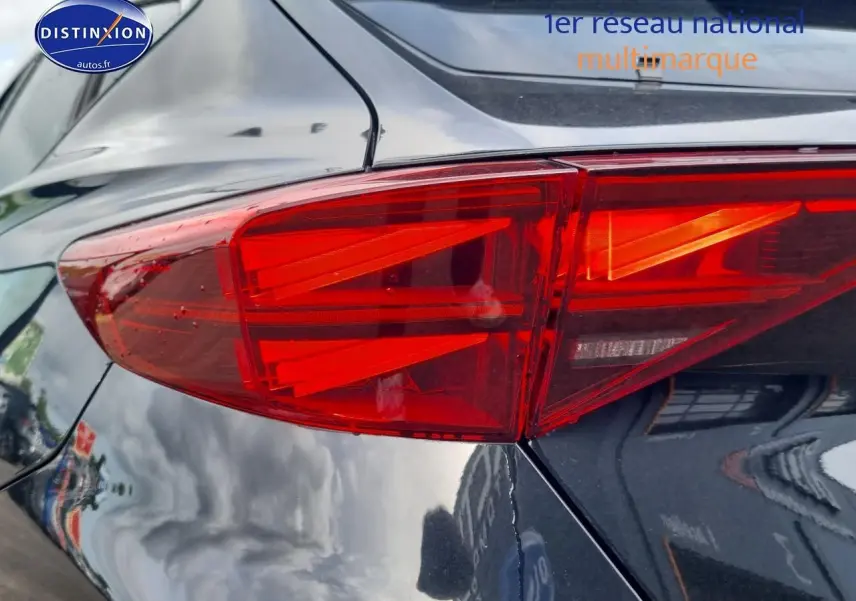 Gros plan sur le feu arrière droit rouge vif d'une CUPRA Formentor noir midnight 2025, reflet sur la carrosserie brillante.