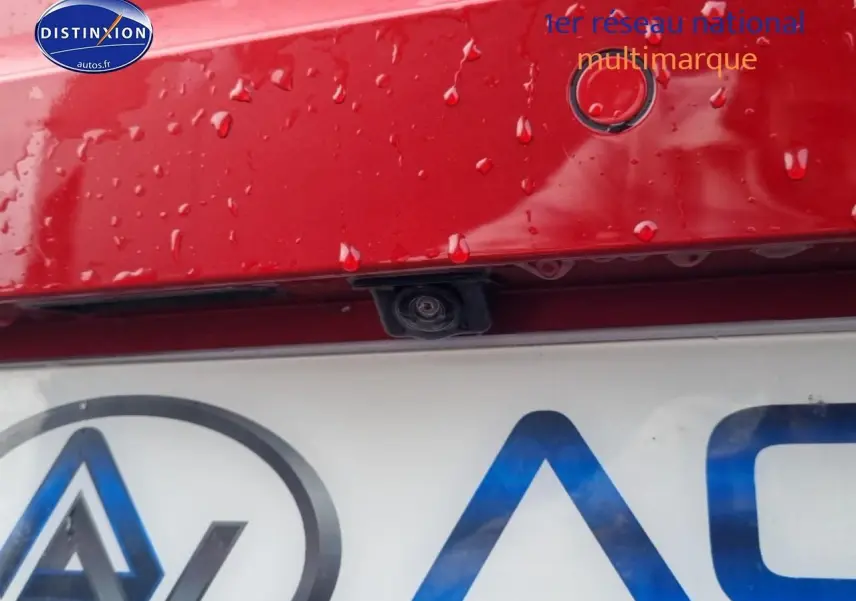 Gros plan sur la caméra de recul et capteur de stationnement sur le hayon rouge désir d'une SEAT Ibiza 2025.