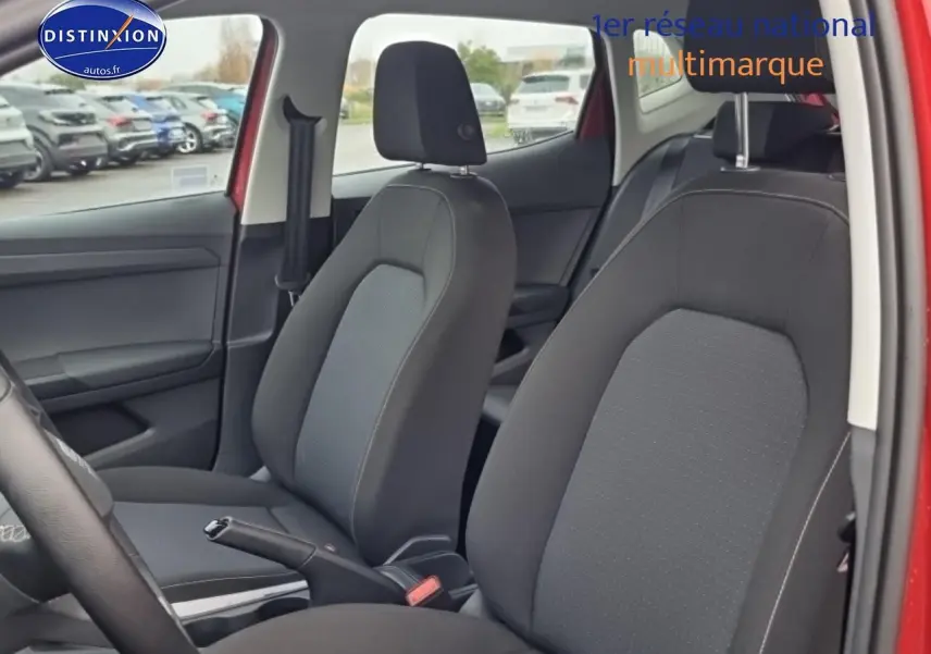 Vue intérieure côté gauche des sièges avant en tissu gris dans une SEAT Ibiza rouge désir 2025.