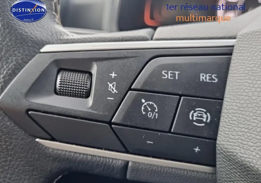 Gros plan sur les commandes du volant multifonction d'une SEAT Ibiza rouge désir, version 2025.