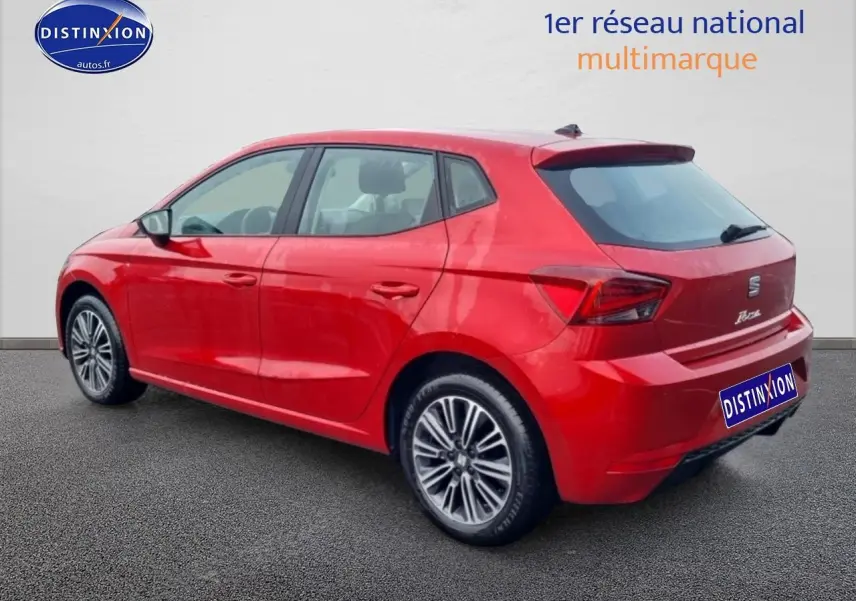 Vue 3/4 arrière droite d'une SEAT Ibiza rouge désir avec jantes alliage et feux arrière LED.