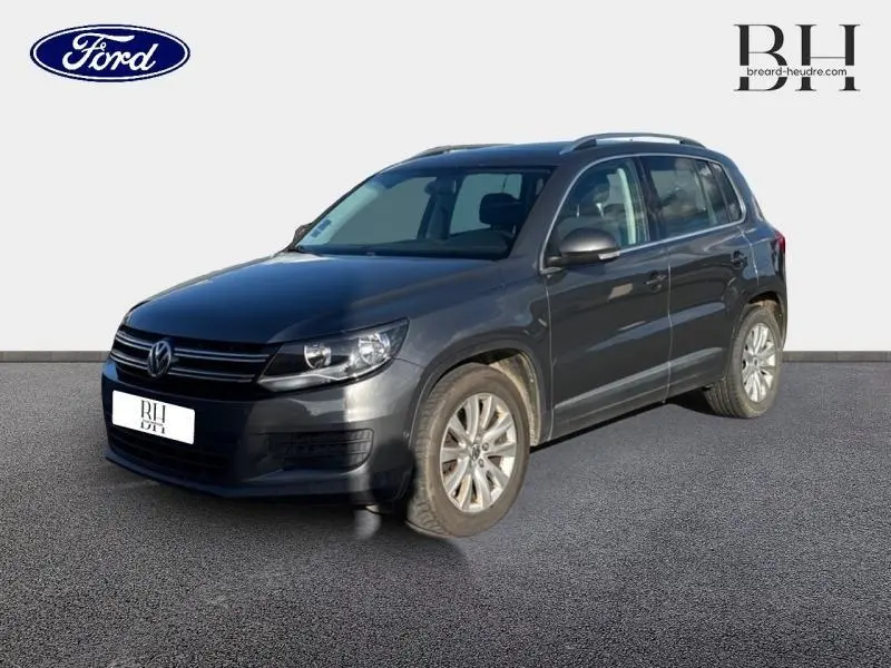 Volkswagen Tiguan gris Crypton vu en 3/4 avant droit, avec calandre chromée et jantes alu visibles.