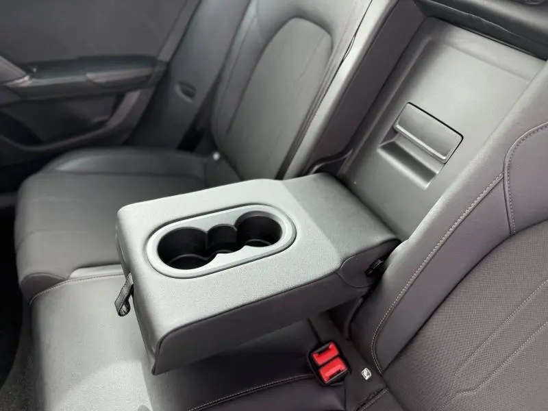 Détail de l'accoudoir arrière avec porte-gobelets sur les sièges noirs du CUPRA Formentor 1.5 eTSI Hybrid 2025.