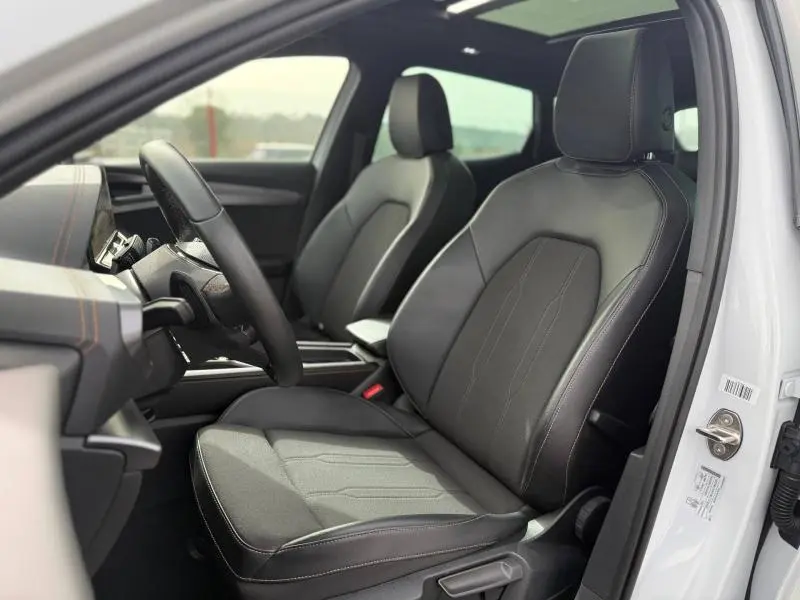 Vue intérieure côté conducteur du CUPRA Formentor blanc Nevada 2025, sièges en cuir noir avec surpiqûres contrastantes.