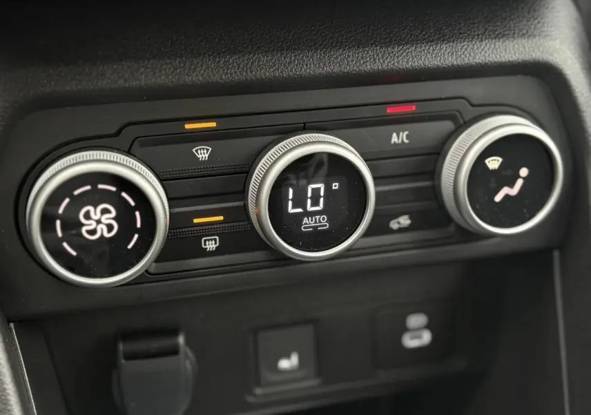 Gros plan sur les commandes de climatisation automatique de la Dacia Sandero Stepway gris schiste, affichant 16°C.