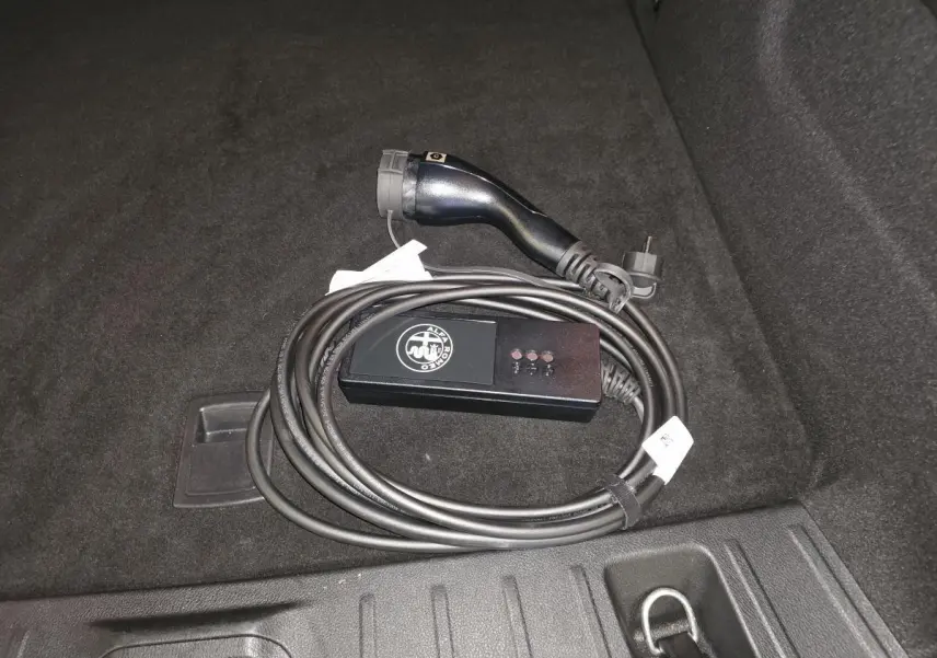Câble de recharge mode 2 Alfa Romeo Tonale 1.3 PHEV 280 TI Q4 posé dans le coffre au revêtement noir.