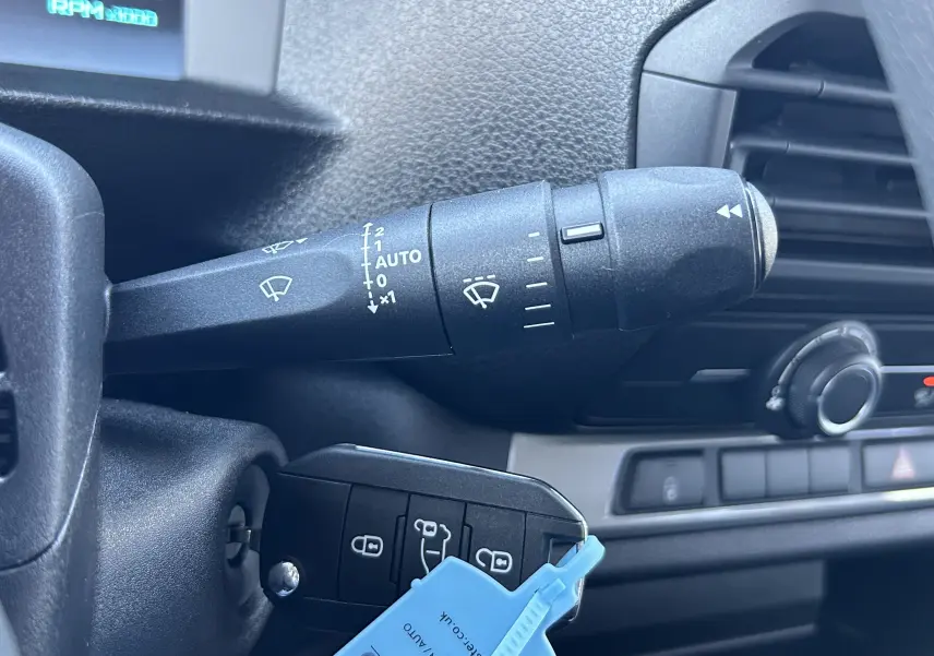 Gros plan intérieur sur la commande d’essuie-glace et la clé insérée d’un Citroën Jumpy Cabine Approfondie noir.
