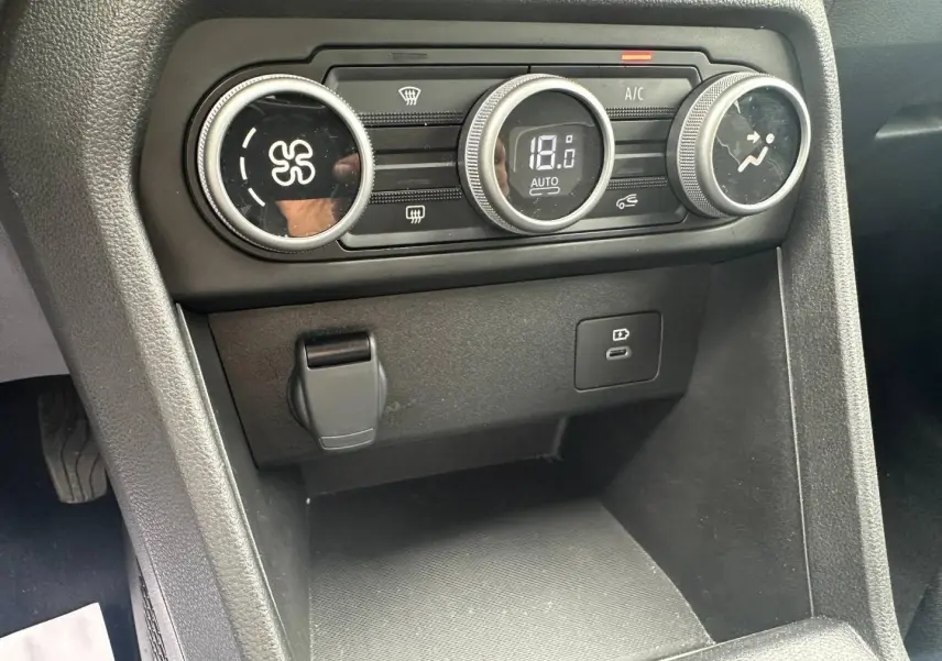 Gros plan sur la console centrale du DACIA JOGGER 2025 montrant les commandes de climatisation digitales et prises USB.